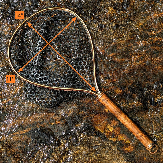 A bamboo fly fishing net lying on a rock in the water on the river in Western North Carolina. The rubber net basket is smooth and shiny and protects the fish for catch and release. The handle is flame cured for strength and durability and there is copper stitching and a copper keeper ring to attach your net keeper to.